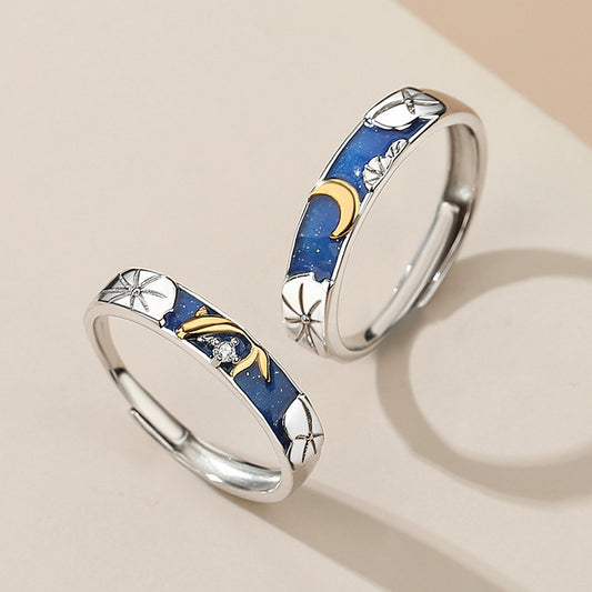 Pair of rings with blue inlay and gold accents on a beige background