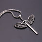 Silver pendant with wings and a sword on a chain against a dark background