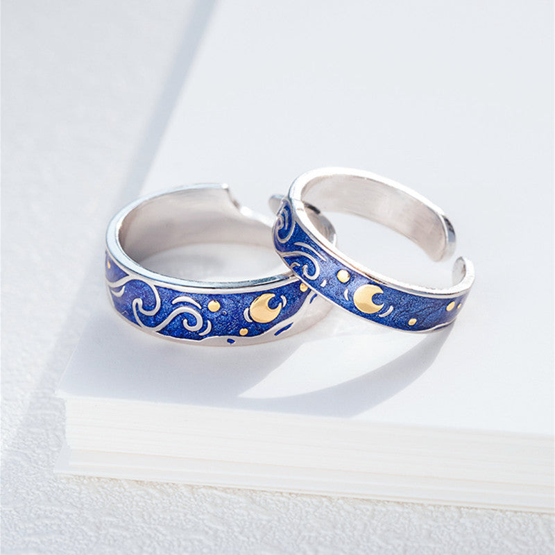 Silver rings with blue and gold designs on a white background
