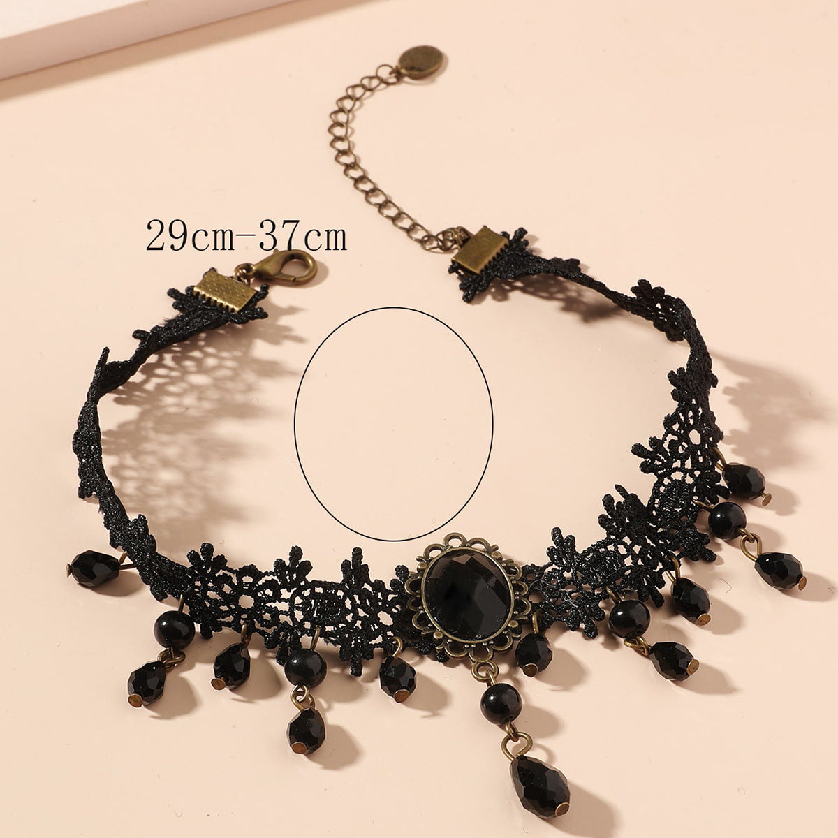 Black lace choker necklace with beads on a beige background