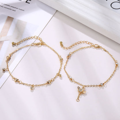Two gold anklets on a white surface with text in the background