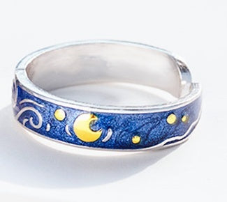 Silver ring with blue band featuring starry night design on a white background