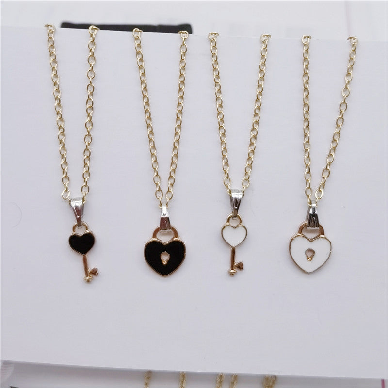 Four gold necklaces with heart and key pendants on a white background